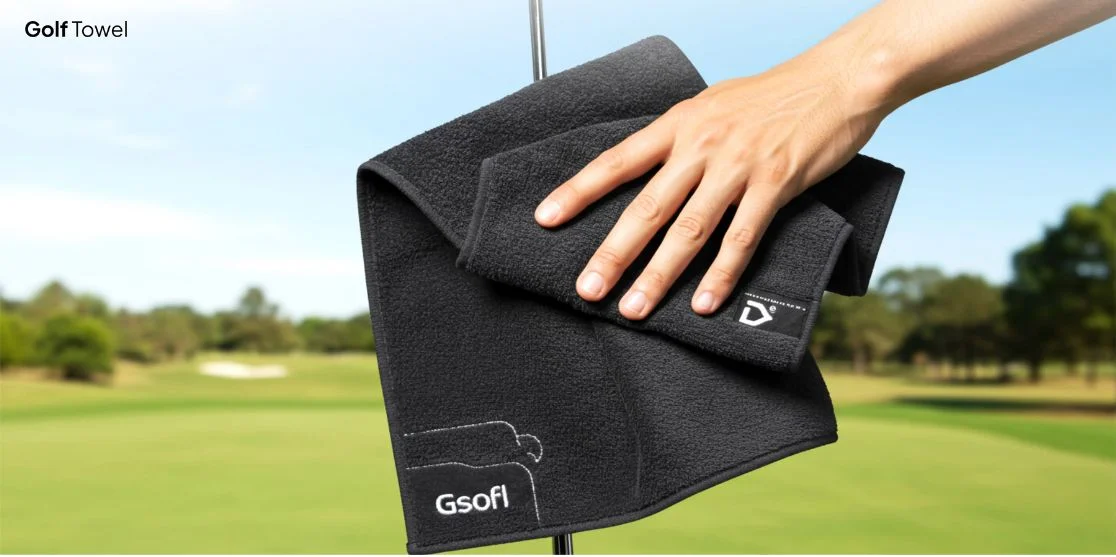 Hand wiping black golf towel.